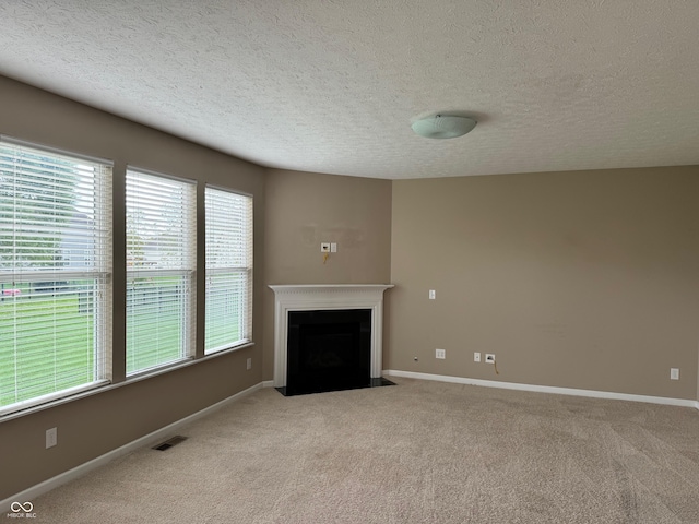 unfurnished living room featuring a textured ceiling and light colored carpet