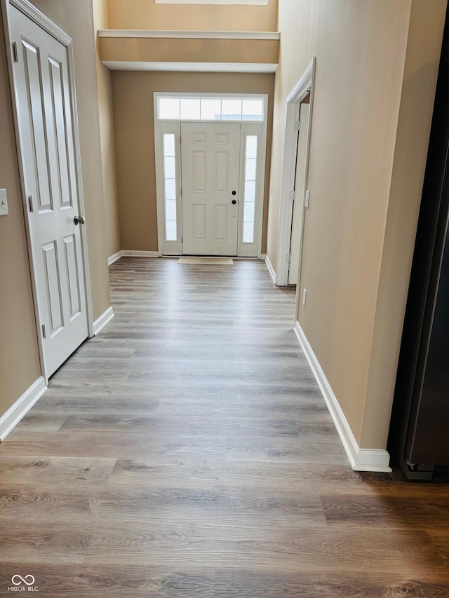 foyer entrance with baseboards and light wood finished floors