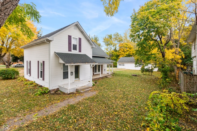 rear view of property with a garage and a lawn