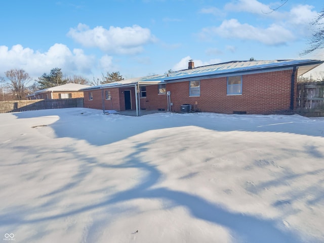 snow covered property with central air condition unit