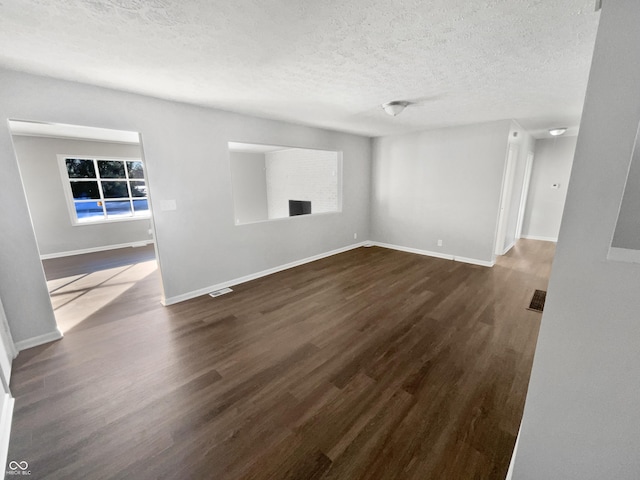 unfurnished living room featuring a textured ceiling, dark hardwood / wood-style floors, and a fireplace