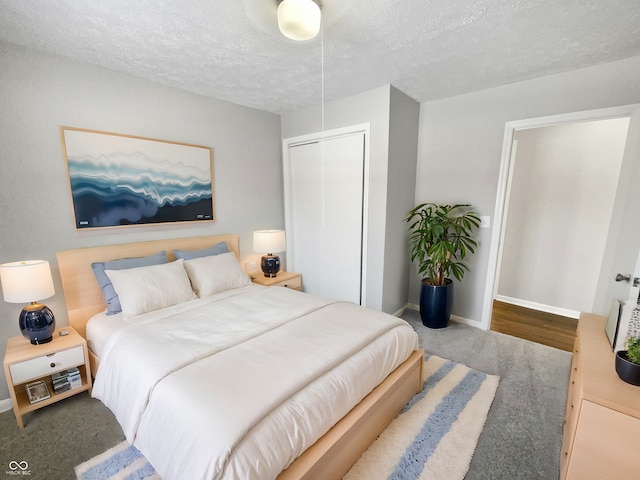 carpeted bedroom featuring a textured ceiling and a closet