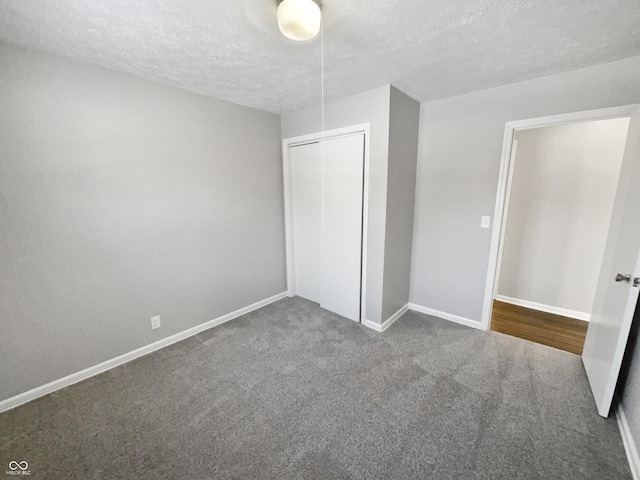 unfurnished bedroom with a textured ceiling, a closet, and carpet flooring