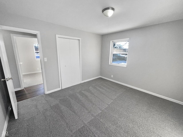 unfurnished bedroom with a closet and dark carpet