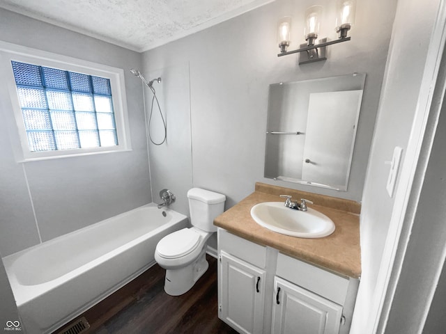 full bathroom featuring toilet, hardwood / wood-style floors, washtub / shower combination, a textured ceiling, and vanity