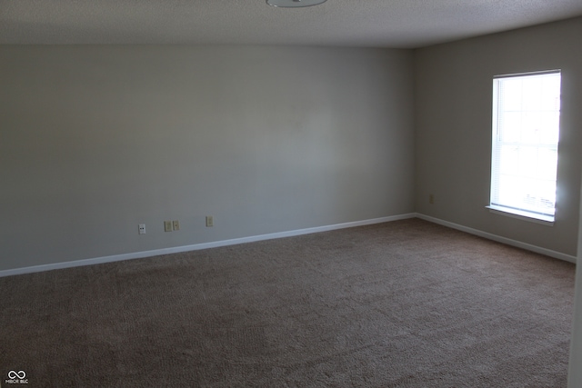 carpeted spare room with a textured ceiling