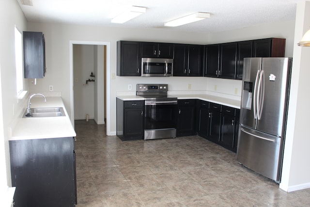 kitchen featuring stainless steel appliances, a textured ceiling, and sink