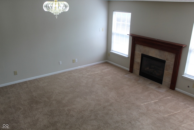 unfurnished living room featuring light colored carpet, a fireplace, and a wealth of natural light