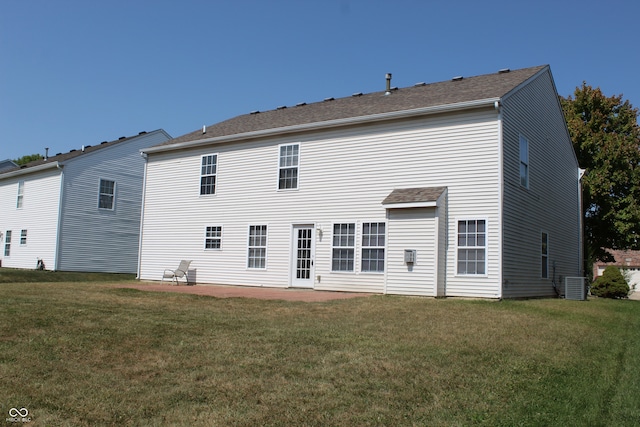 rear view of property with a lawn, a patio, and central AC