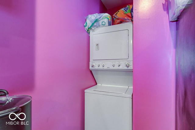 clothes washing area featuring stacked washing maching and dryer