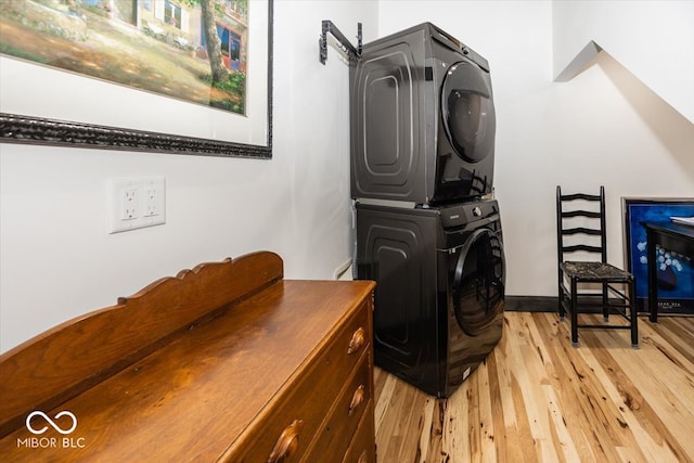 laundry area featuring light hardwood / wood-style floors and stacked washing maching and dryer