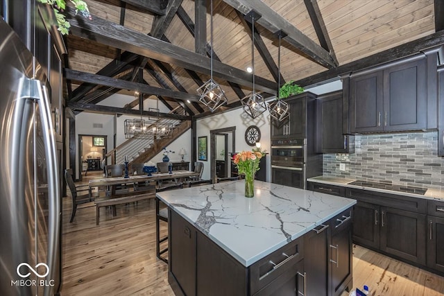 kitchen featuring black appliances, a breakfast bar area, light hardwood / wood-style flooring, and a center island