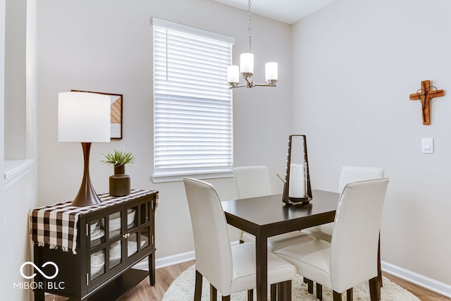 dining space with wood-type flooring and a chandelier