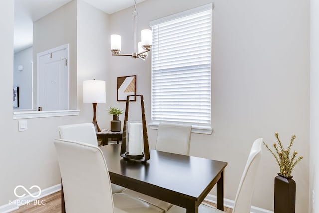 dining space with a healthy amount of sunlight, an inviting chandelier, and hardwood / wood-style flooring