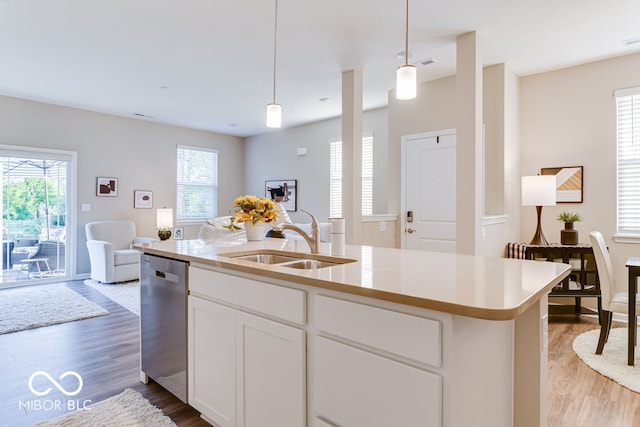 kitchen featuring pendant lighting, sink, an island with sink, white cabinets, and stainless steel dishwasher