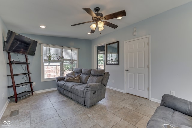 living room with ceiling fan, light tile patterned flooring, and lofted ceiling