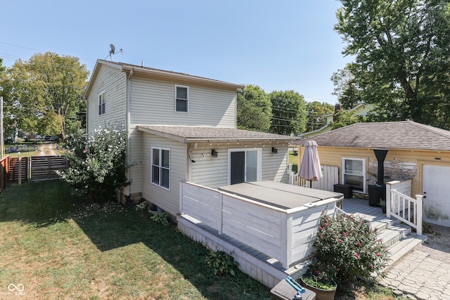 rear view of property with a deck and a yard