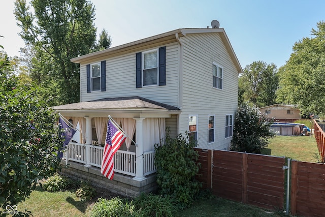 view of front of house featuring a fenced in pool, a front lawn, and a porch