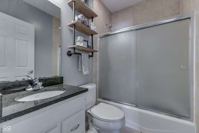 full bathroom with shower / bath combination with glass door, vanity, and toilet