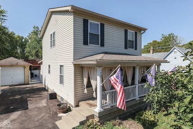 view of front of property with covered porch, an outbuilding, and a garage