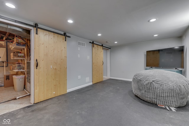 interior space with a barn door and ensuite bathroom