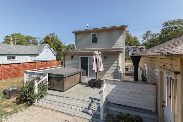 back of house featuring a deck and a hot tub