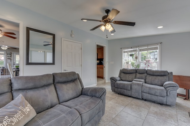 living room with ceiling fan, light tile patterned flooring, and lofted ceiling