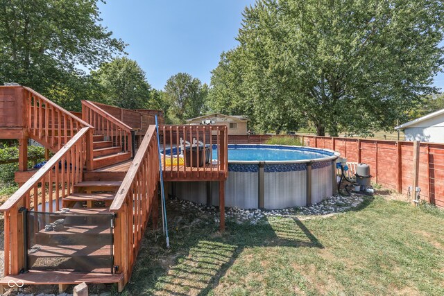 view of pool featuring a wooden deck and a lawn