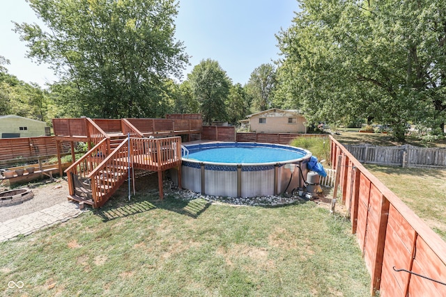 view of pool with a lawn and an outdoor fire pit