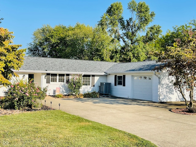 ranch-style house featuring a front yard, a garage, and central air condition unit