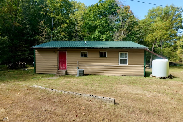 exterior space featuring central AC and a front lawn