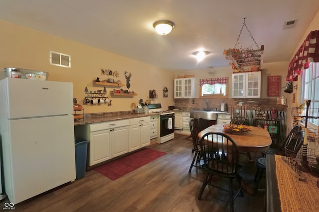 kitchen featuring tasteful backsplash, white cabinets, white appliances, light stone countertops, and dark hardwood / wood-style floors