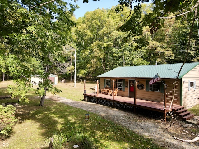 exterior space featuring a lawn, covered porch, a garage, and an outbuilding