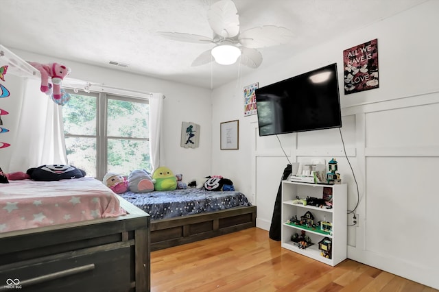 bedroom featuring wood-type flooring, a textured ceiling, and ceiling fan