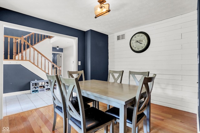 dining area featuring wood-type flooring and a textured ceiling