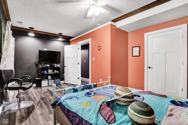 bedroom with a textured ceiling, ornamental molding, hardwood / wood-style floors, and ceiling fan