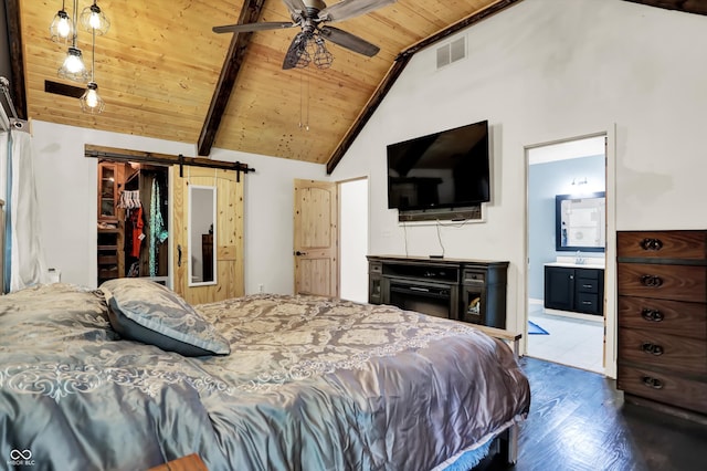 bedroom with wood ceiling, a barn door, connected bathroom, hardwood / wood-style floors, and ceiling fan