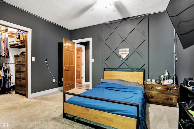 carpeted bedroom with ceiling fan and a textured ceiling