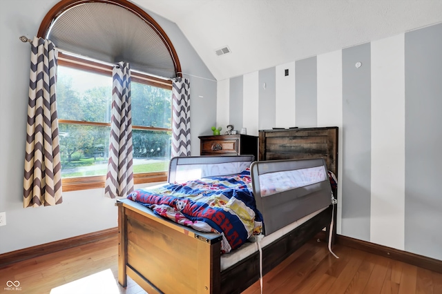 bedroom with wood-type flooring and lofted ceiling