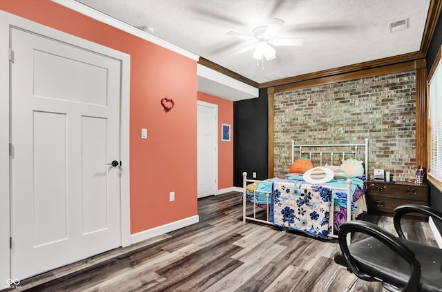 bedroom featuring a textured ceiling, wood-type flooring, crown molding, and ceiling fan