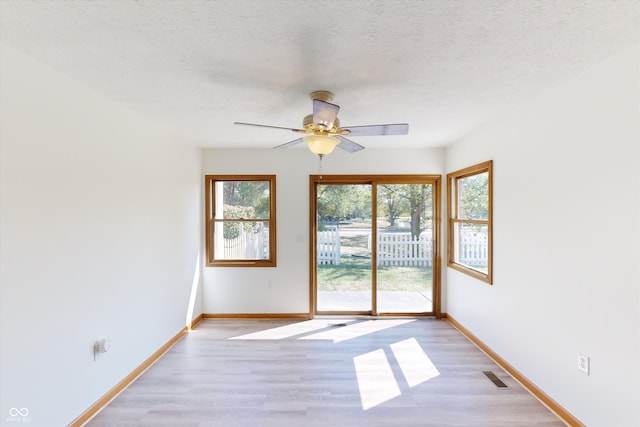 unfurnished room with ceiling fan, a textured ceiling, and light hardwood / wood-style flooring