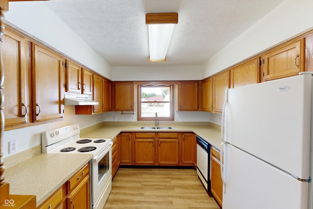 kitchen with white appliances, light hardwood / wood-style floors, a textured ceiling, and sink