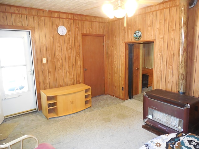 carpeted bedroom featuring ceiling fan and wooden walls