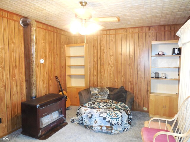 interior space with ceiling fan, wooden walls, and carpet flooring