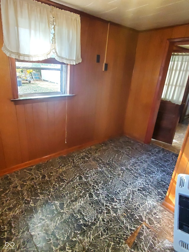 spare room with wooden walls and heating unit