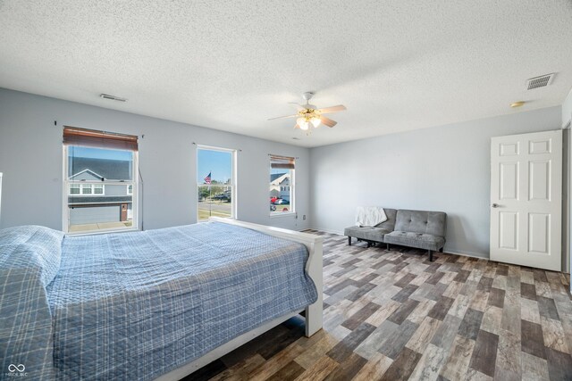 bedroom with hardwood / wood-style floors, a textured ceiling, and ceiling fan