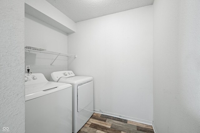 washroom featuring washer and dryer, dark wood-type flooring, and a textured ceiling