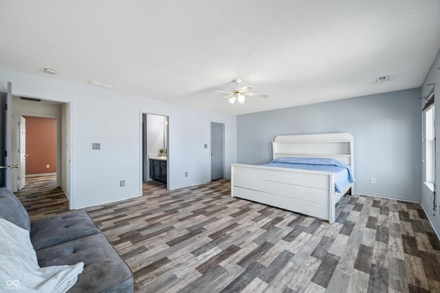 bedroom featuring ensuite bathroom, hardwood / wood-style flooring, a textured ceiling, and ceiling fan