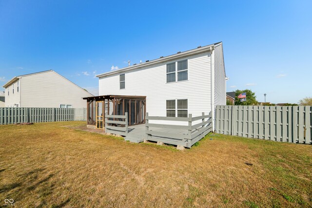 rear view of house with a yard and a deck