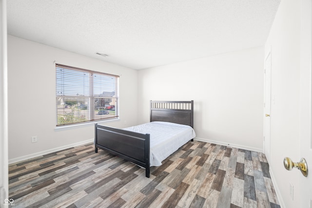 bedroom featuring dark hardwood / wood-style floors and a textured ceiling